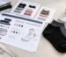 Custom sock development workspace with sock samples, yarn colour references, technical specification sheets and measuring tools